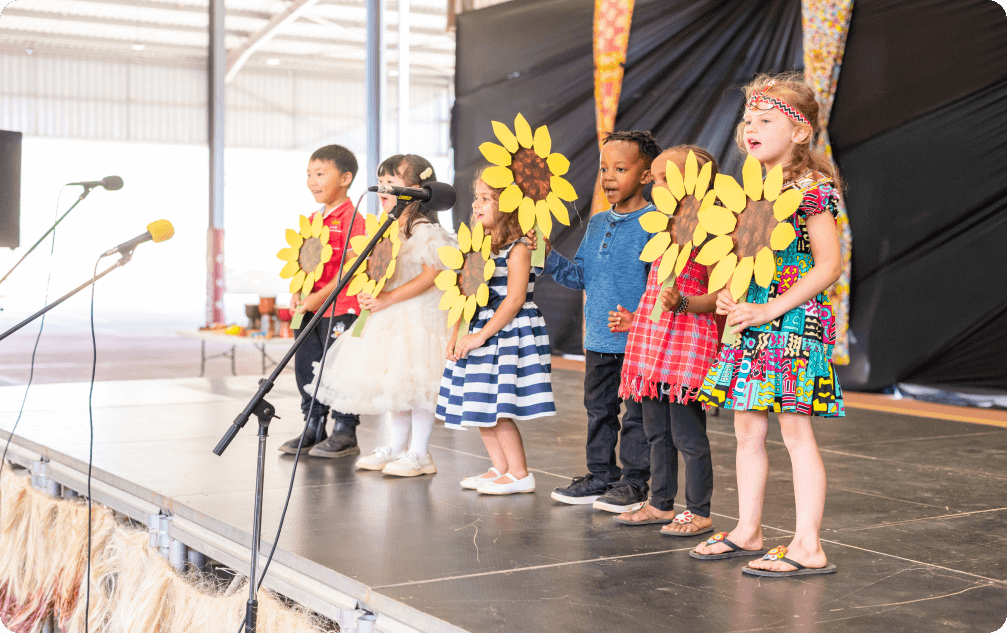 Little kids on stage in sunflower costumes
